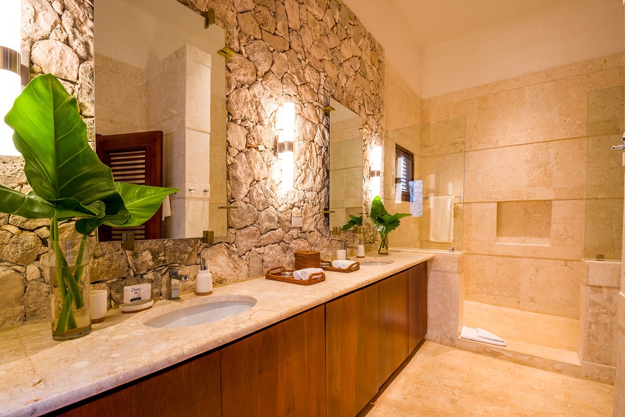 Modern ensuite bathroom with a stone accent wall and double sinks.