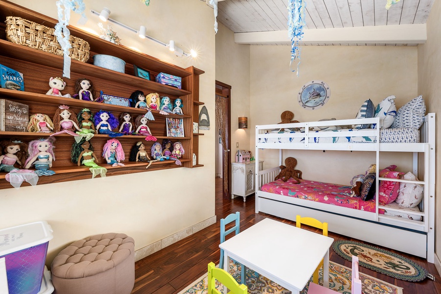 Bunk bed with trundle and a full wall of toys and games—designed for fun, play, and sleepovers alike.