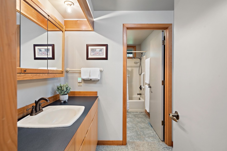 The communal bathroom comes with a shower/tub combo and ample single sink vanity space.