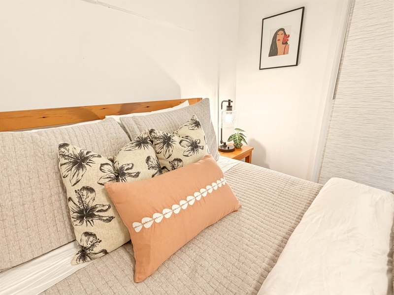 Drift off in your cozy bedroom featuring botanical pillows and warm coral accents for restful nights.