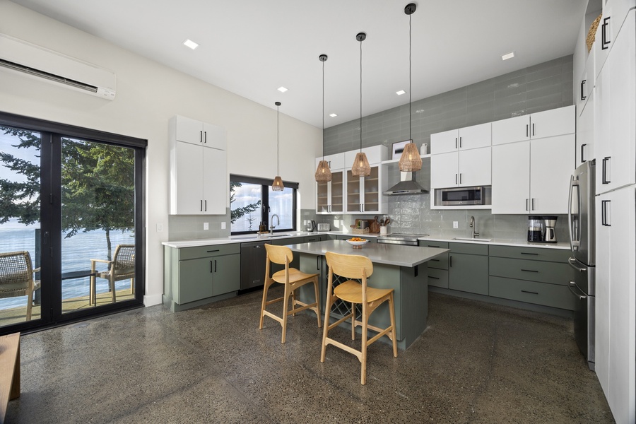 Chef-ready kitchen with modern appliances, breakfast bar seating, and warm natural light throughout.