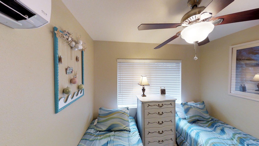 The third guest bedroom has twin beds and a tall dresser with antique pearl detail.