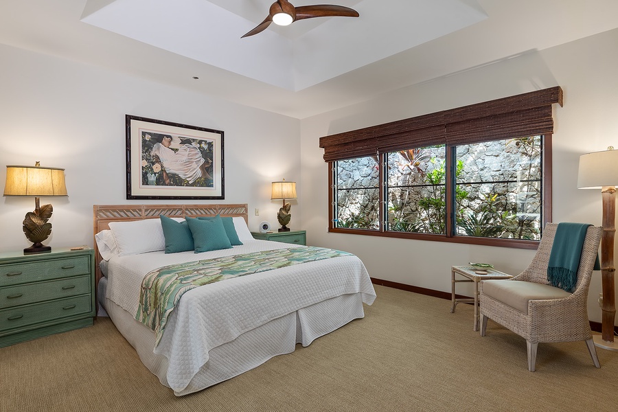 Beach house guest bedroom with a king-size bed and large windows for natural light and tropical views.