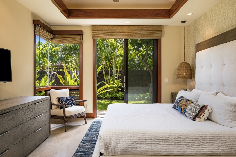 Guest bedroom two, off the kitchen, boasts sliding doors to a private lanai with lawn area.
