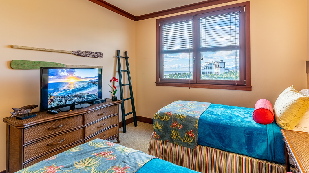 The second guest bedroom features bright patterns and a smart TV.