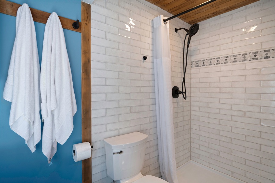 Clean, modern tile and dark fixtures create a spa-like shower experience for guests to unwind.