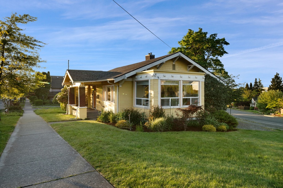 Arrive at this charming yellow cottage tucked along a quiet residential street.