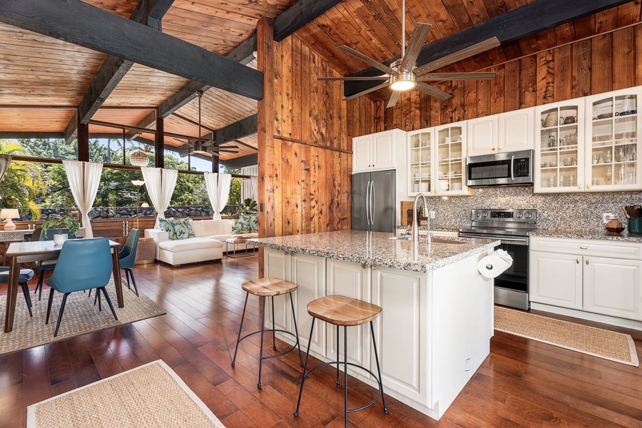 You'll love cooking in this stunning open kitchen with granite counters and modern appliances, all beneath soaring beams and tropical views.