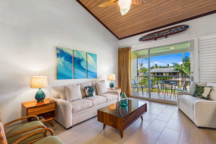 Relax in this cozy living area featuring high ceilings and vibrant decor, with easy access to the lanai for enjoying the fresh island breeze.