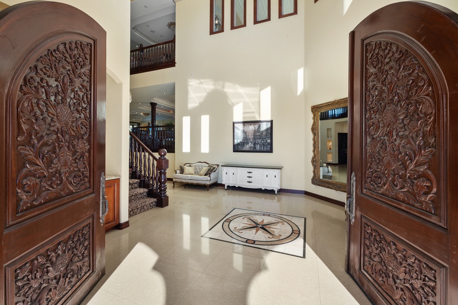From the hand-carved wood doors to the soaring foyer beyond, every detail speaks to exceptional craftsmanship.