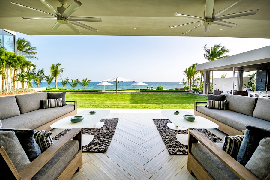 Unwind in the outdoor living area with ample seating and spectacular views of the ocean and lush landscape.