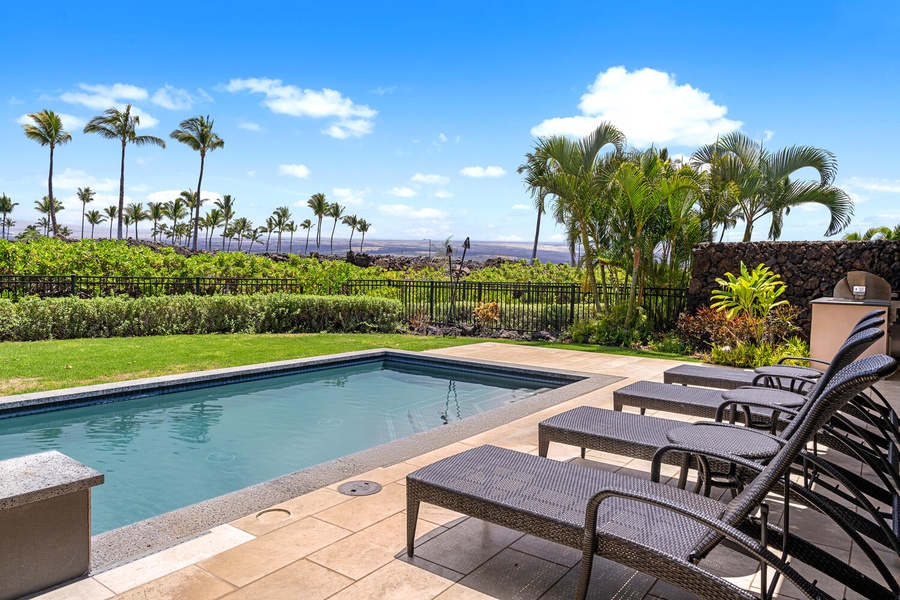 Unwind poolside with panoramic views of the Mauna Lani golf course.