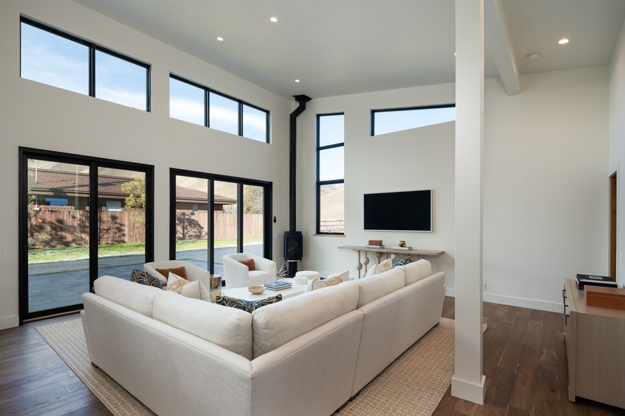 Stylish living space with high ceilings and floor-to-ceiling windows, creating an airy and inviting atmosphere for relaxation and socializing.