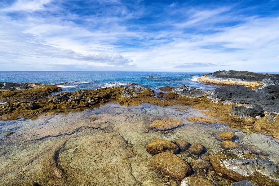 Crystal-clear tide pools and oceanfront textures set a dramatic coastal scene.