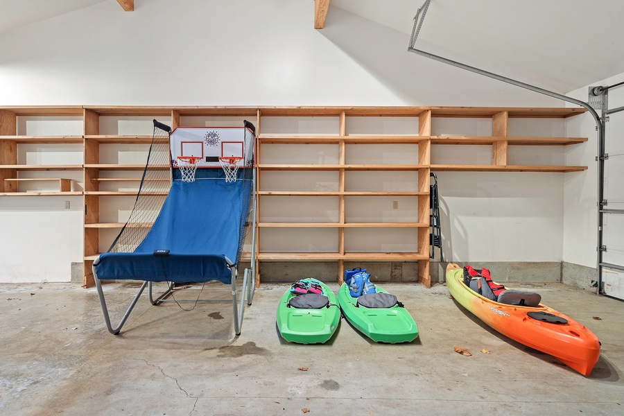 large 2-car garage with a hobby room and carport, a Peloton bike, 1 adult and 2 kids kayaks, and a ping pong table for added entertainment and enjoyment.