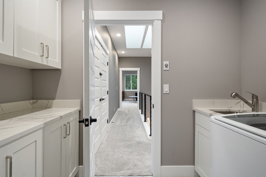 Offers sleek white cabinets and marble countertops, perfect for preparing meals during your stay.