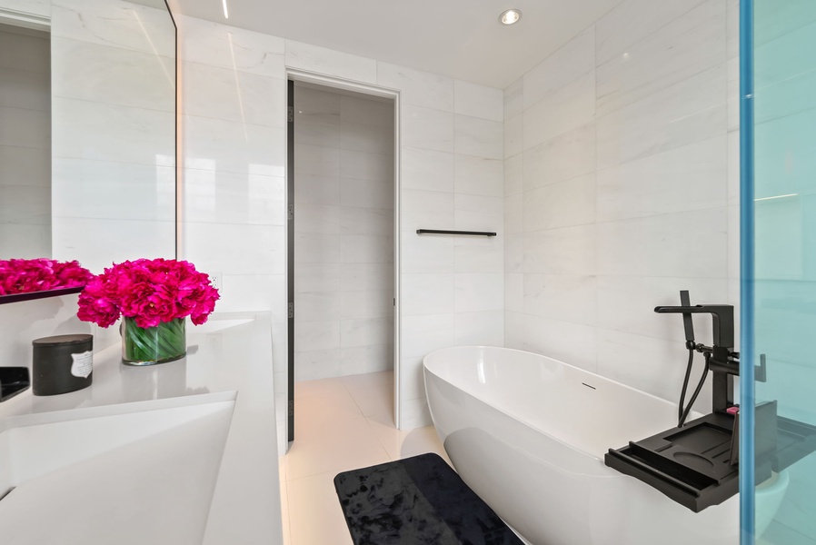 Unwind in the soaking tub while surrounded by clean-lined tile and calming touches that echo the home’s modern design aesthetic.