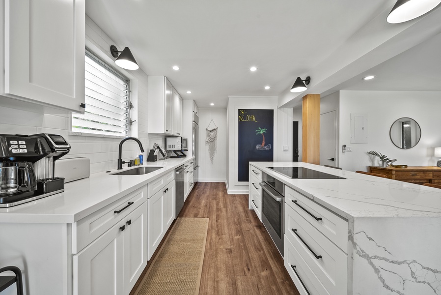 Gourmet kitchen with premium appliances and white cabinetry, creating a bright and inviting space to prepare island-inspired meals.