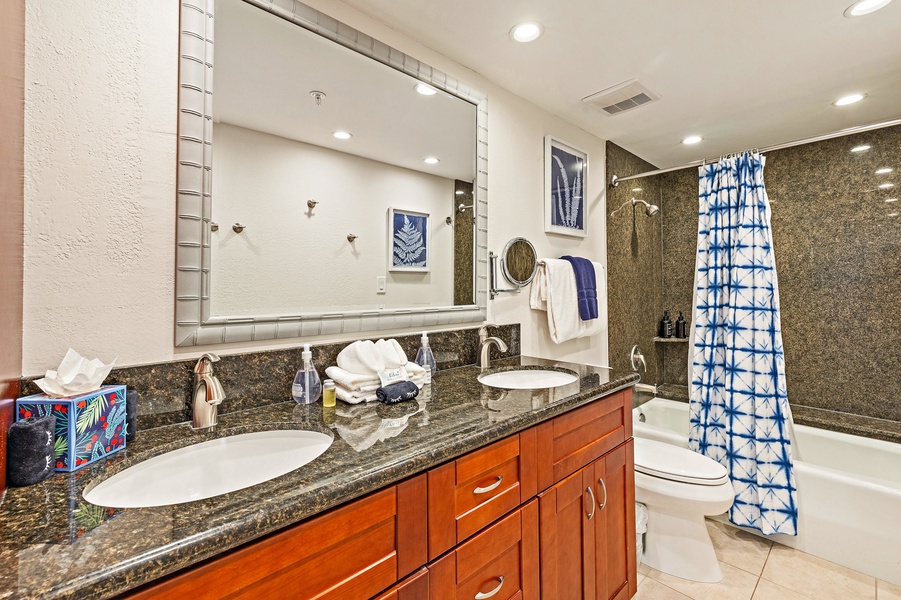 Kaanapali Shores 903’s bathroom features a granite vanity and bright, modern lighting.