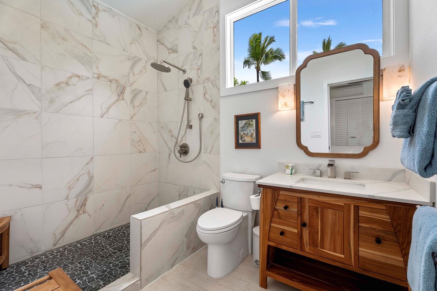 The ensuite guest bathroom with natural lighting and separate walk-in shower.