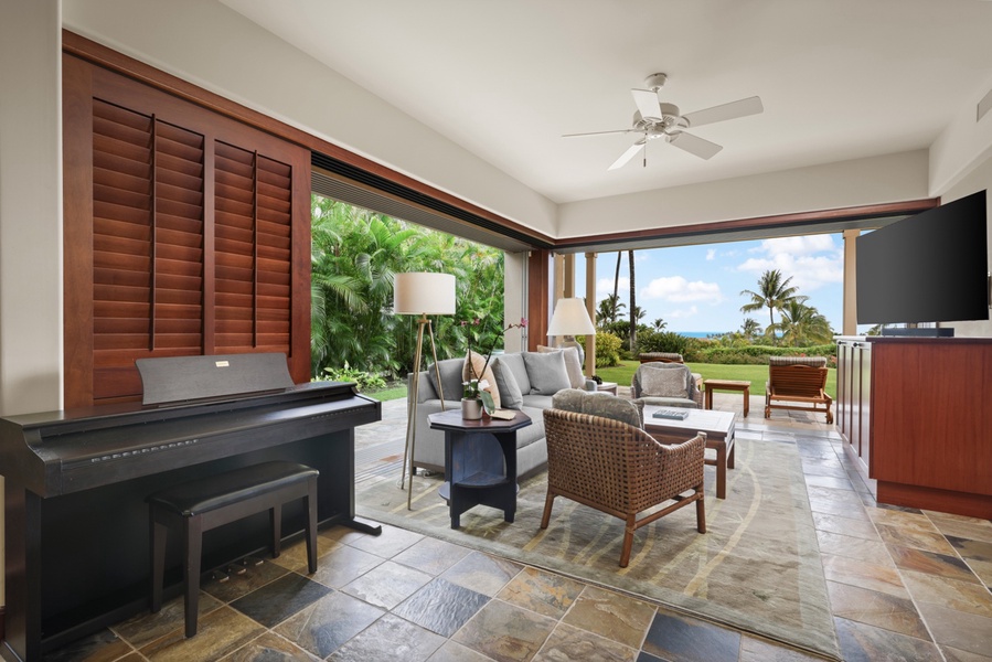 Retreat room with flat screen television, desk, plush seating and lanai.