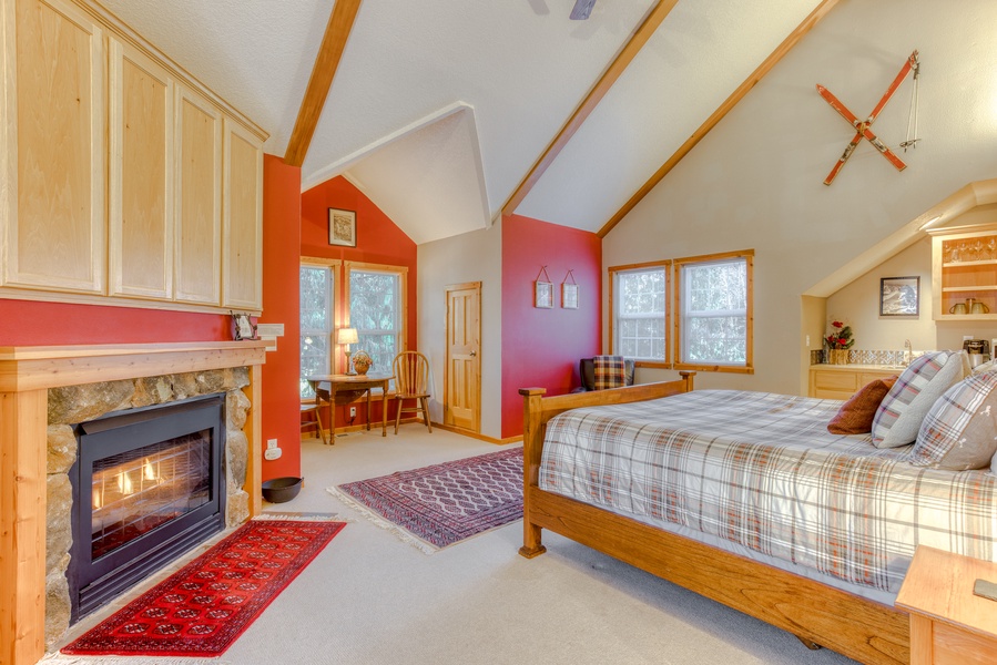 Relax in the primary bedroom, boasting a cozy gas fireplace, large windows, and a private seating area for ultimate comfort