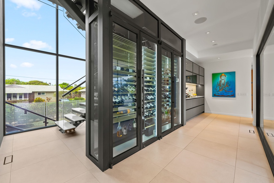 Walk-in wine room with floor-to-ceiling glass and sleek, modern storage.