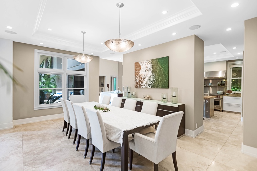 Formal dining for ten with soft lighting and views of the lush grounds.