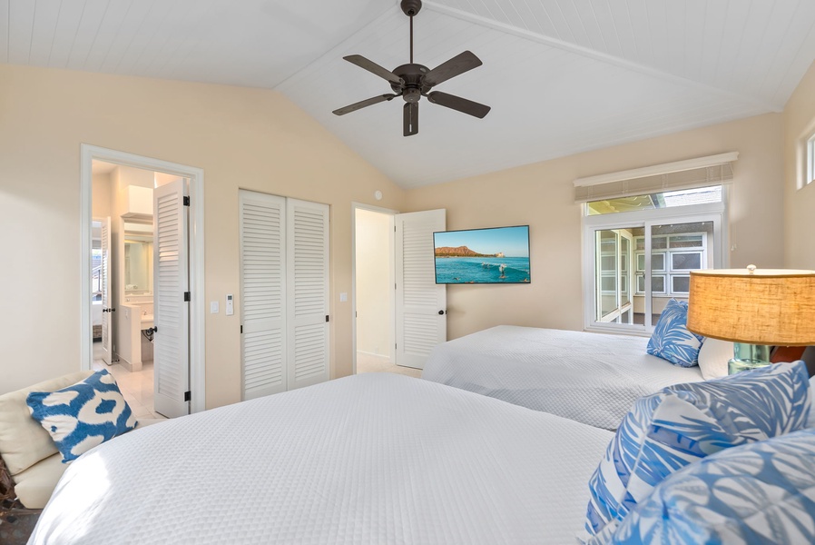Drift off in this bright coastal bedroom with twin beds, ceiling fan, and tropical touches that promise peaceful sleep.