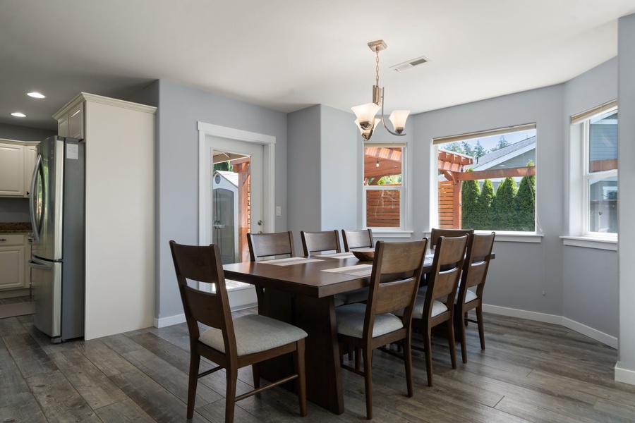 Enjoy meals together in the sunlit dining space overlooking the peaceful backyard and surrounding neighborhood greenery.