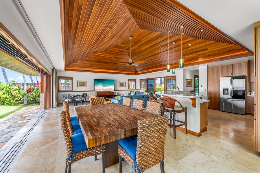 Gather for meals at the spacious dining table, set beneath vaulted ceilings and surrounded by island-inspired décor.