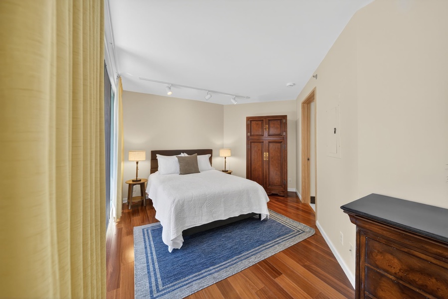 Rest comfortably in this serene bedroom with hardwood floors and classic island style.