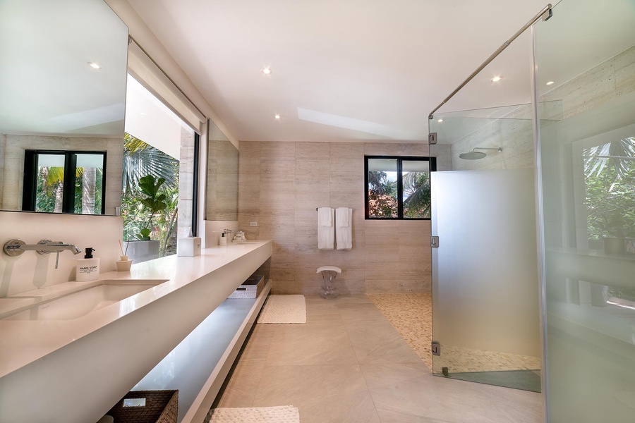 Spacious ensuite bathroom with a large walk-in shower, double sinks, and modern finishes, enhanced by natural light.
