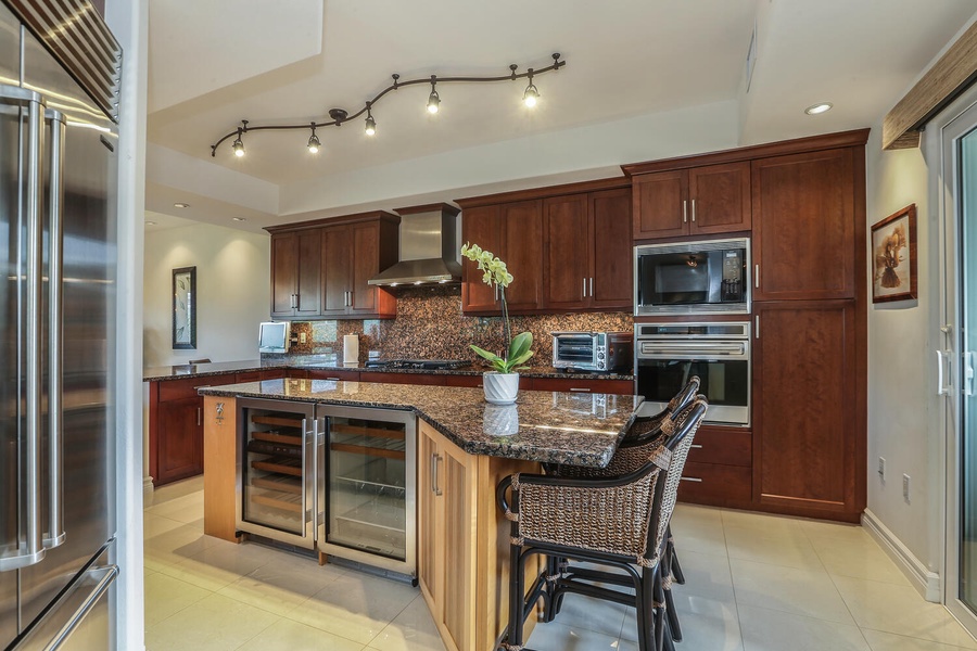 granite countertops and stainless steel appliances, including a Jenn Air gas range and sub zero fridge.
