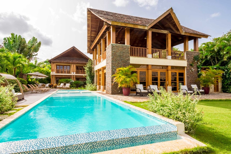 The spacious outdoor pool and stunning villa, ideal for a relaxing vacation.