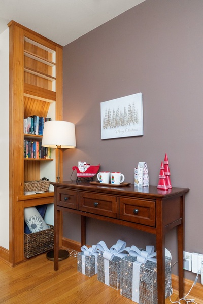 Entryway table decorated with festive accents and holiday-themed mugs.