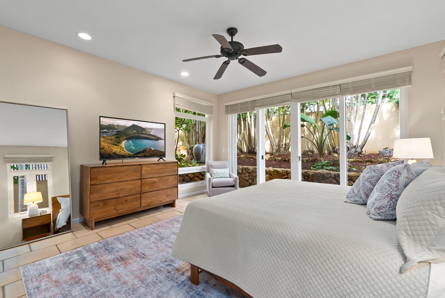 Your serene bedroom opens to a private tropical garden, where natural light filters through lush greenery while you relax in modern comfort.