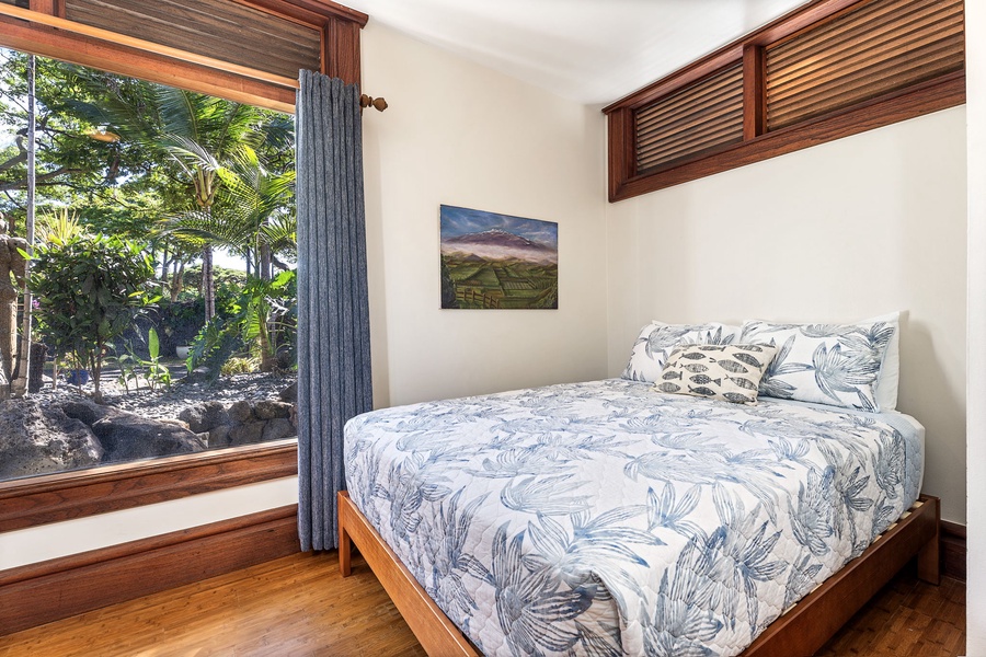 Wake to tropical garden views from your cozy bedroom, where natural wood details and island-inspired linens create a peaceful retreat.