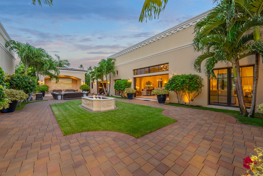 Beautiful courtyard with manicured lawns, a fountain, and inviting pathways, ideal for outdoor gatherings.