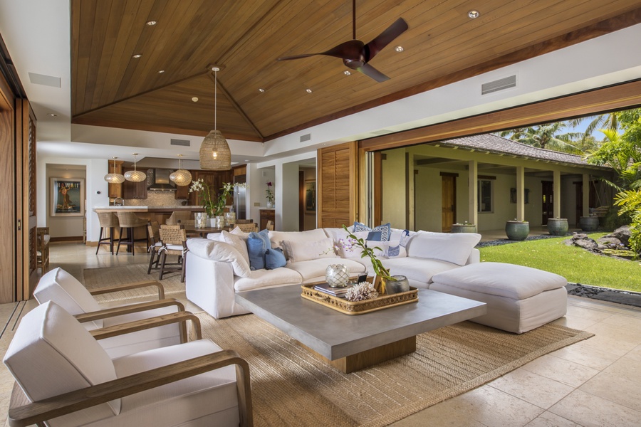 Side angle of great room featuring soaring vaulted ceilings, plush seating & chic, modern decor