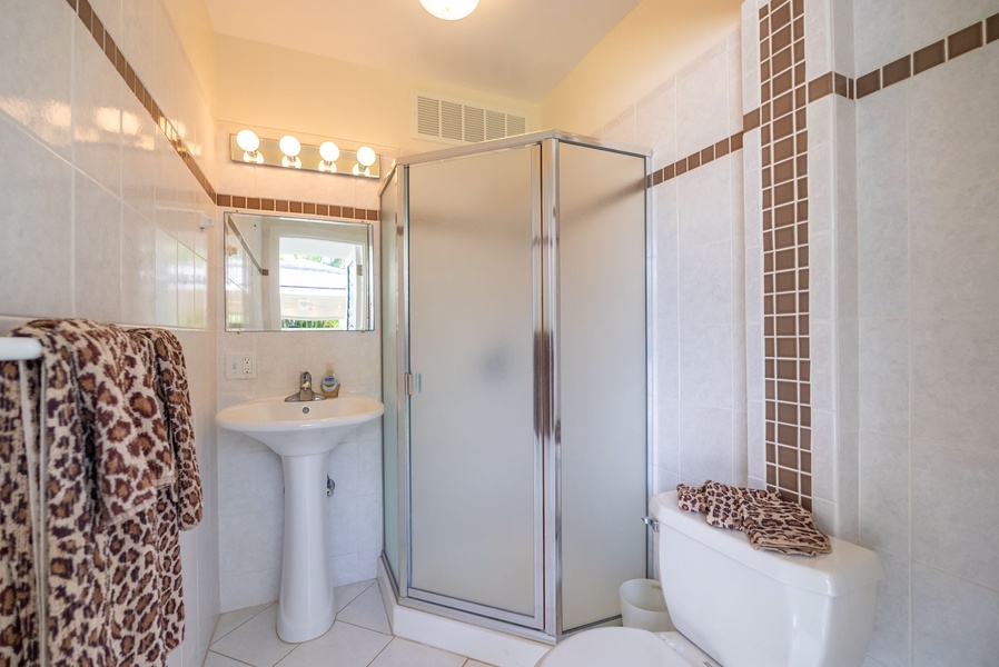 Modern bathroom with a frosted glass shower and sleek fixtures for a clean and contemporary feel.