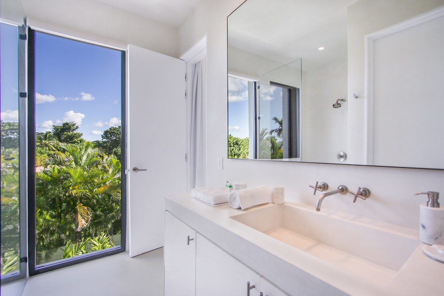 Ensuite bathroom with a beautiful view of the surrounding greenery.