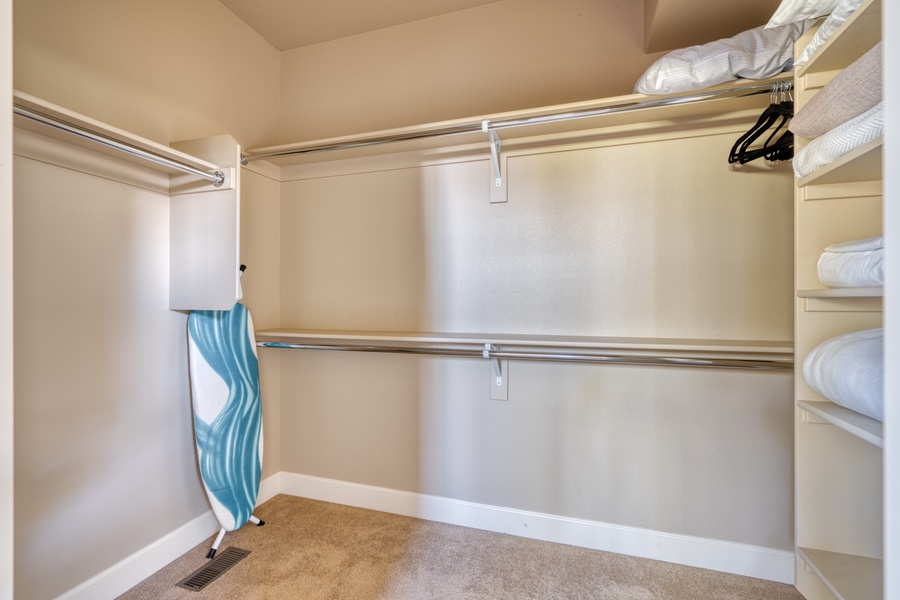 Inside the walk-in closet of the primary bedroom, discover a well-organized space with shelves and hanging rods, making it easy to keep your wardrobe neat and accessible.