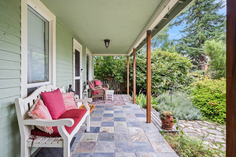 Unwind on this classic front porch with comfy wicker chairs, the perfect spot for chatting or enjoying a peaceful moment.