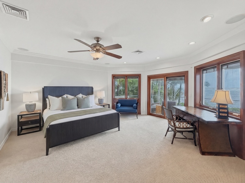 Your elegant suite features a cozy bed, work desk, and stunning ocean views from expansive windows.