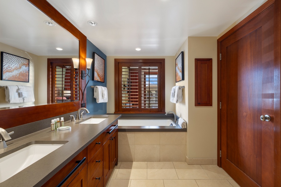 The primary guest bathroom has a large soaking tub and dual vanities.