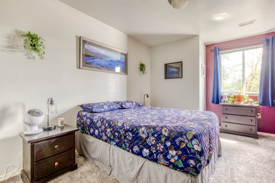 The Guest bedroom is furnished with a Queen bed, flatscreen television, and views over the garden