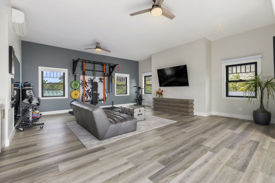 The wellness and fitness room comes with weights & exercise equipment for an in-home workout or yoga session and a small fridge for a cool post-workout drink