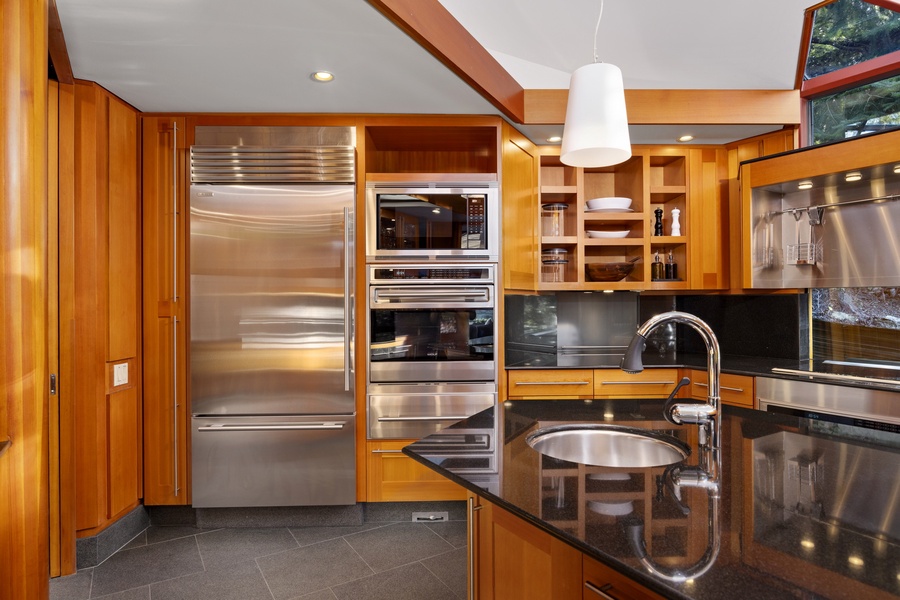 Your gourmet kitchen features rich wood cabinetry, granite countertops, and premium stainless steel appliances for memorable cooking experiences.