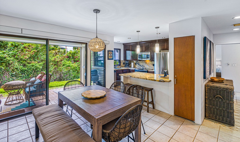 The open-concept dining area and kitchen offer a seamless transition to the lanai, perfect for enjoying meals indoors or stepping outside to take in the garden views.